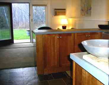 Kitchen area looking out onto lawn, birches, maples, and mountains above