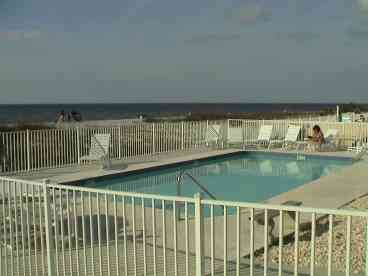 The pool overlooks the beach and has seating around