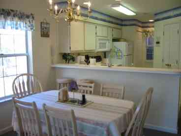 The recently updated kitchen featuring a breakfast bar and dining area, both with newer chairs/stools.