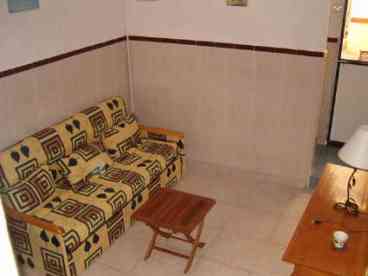 Living Area: Open plan living area furnished with a comfortable sofa-bed, table and chairs. 

