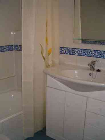 Modern bathroom with bath/shower, toilet and basin. 
