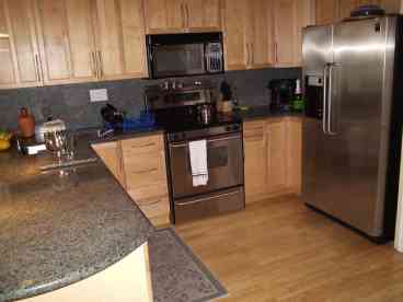 The kitchen with Frigidaire Gallery Series stainless steel appliances. Filtered water, ice and crushed ice on refrigerator door. Microwave and electric glass top stove and oven.