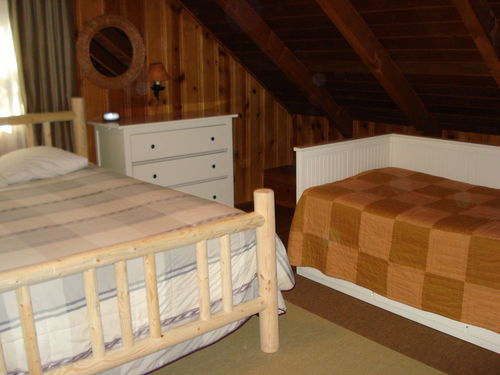 Queen sized bed and day bed in bedroom