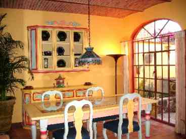 Large Dining room decorated in fabulous Mexican colors that can easily entertain six people.