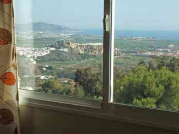 View over forest to castle, sea and mountains from inside villa