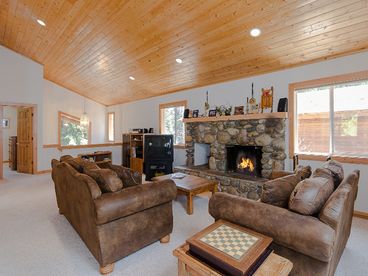 Spacious Living Room w/ paneled ceiling is light, bright, and airy.  Beautiful river rock fireplace for winter warmth and summer cool.