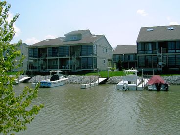 View of condo from the back showing the boat docks at the back door. Condo is upper right