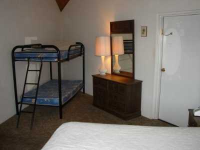 Queen bed in foreground & bunkbed in background.