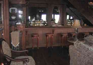 Saloon and Great Room: Dark wood, large fireplace and book-lined shelves.