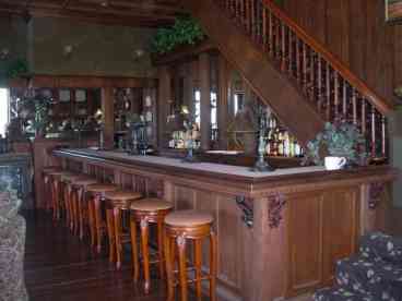A full 12-barstool saloon bar with oval mirror and fluted columns.