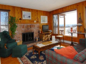 Second floor living room with fireplace, large windows with scenic view