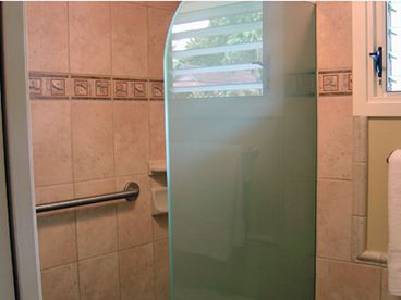 New tiled walk-in shower with glass splash