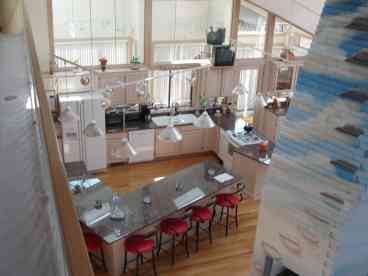 This is a view of the beautiful, large kitchen and floor to ceiling fireplace.