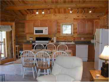 Located on the upper level, the open country styled kitchen adjoins the living room area, with huge slate rock fireplace!
French doors lead to the wrap around deck with covered porch.