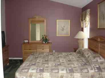 Master bedroom with king size bed, TV, VCR and clock radio.