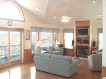 Greatroom on the upper level boasting incredible view of the ocean and gas fireplace. Open to Dining area and Kitchen.