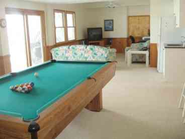 Ground floor gameroom/den with pool table. Wetbar and additional refrigerator also shown, easily accessed by pool area. 