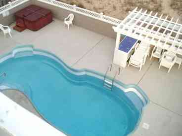 Private pool and hot tub shown. Tiki bar with mini-refrigerator also pictured.