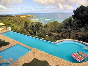 Relax in your private villa pool overlooking the ocean and beach below.