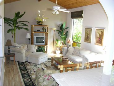 Tropically decorated, cathedral ceiling, light, bright sunken living room faces back yard for total privacy and is open to kitchen and eating bar with big bamboo chairs