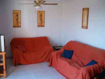 A good size room furnished with two sofas, coffee table, pine dining table & six chairs, pine dresser with cupboards and drawers, Colour T.V. with English satellite Channels & patio doors leading to large Balcony with sea & country views, with patio furniture for outside dining