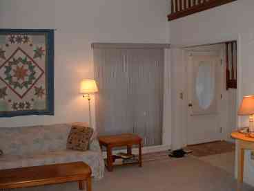 living area with stone fireplace and cathedral ceiling