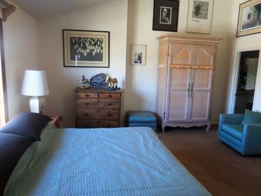 Facing the bathroom door at the back, east windows behind the bed