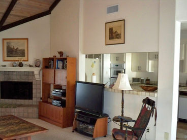 This is facing the front door, which is next to the fireplace. Kitchen beyond the wall shown