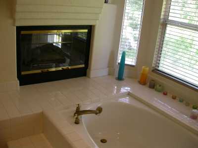 Master bedroom gas fireplace overlooking bathroom bathtub.