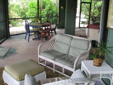 The lower level recreation room with wicker sitting area to enjoy the tropical gardens that surround it,. There is also an indoor hammock, foos-ball  and poker table for your enjoyment.