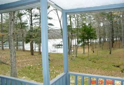 Covered balcony opens up into a covered deck area and steps lead down to patio and porch.  All overlook the backyard and waterfront.