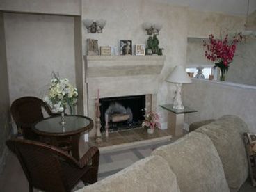 Part of the large living room is a fireplace with seating.  A great place to set up your lap top.