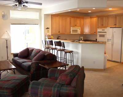 Our open living area showing the living room and kitchen, with bar and stools