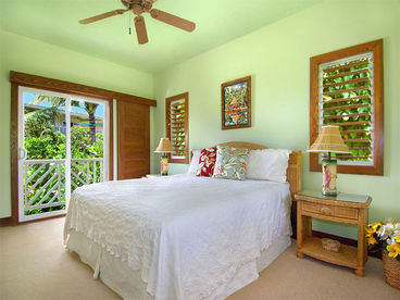 The large master bedroom has a firm California king bed, TV, and a lovely garden view.