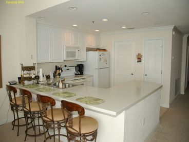 This lovely living room features a queen sofa, fireplace, 40' of ceiling to floor glass with full view of the ocean.  Sit at the game table and see the ocean, pool, and sea life swim by.  Walk out on the balcony from the living room, and hear the ocean, swing on the porch swing, or layout and sun.