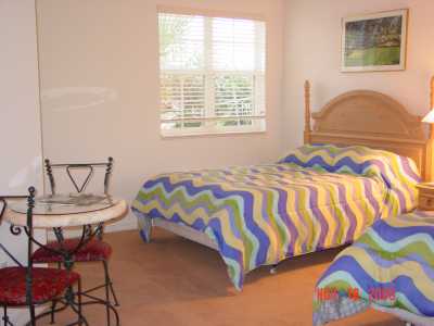 This bedroom has two full beds, a table with two chairs and has its own full bathroom with a kitchentte. The kitchenette has a coffee maker and a microwave.