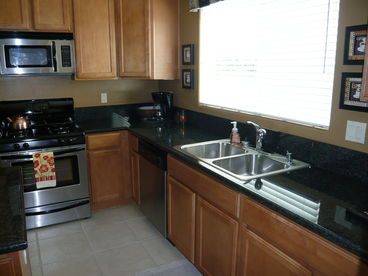 Fully Equipped Modern Kitchen with Granite Countertops and Stainless Steel Appliances.