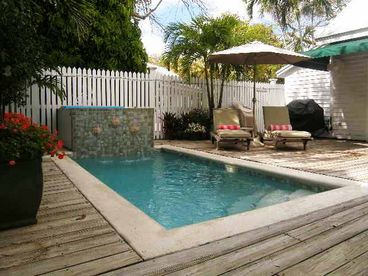 A newly tiled and resurfaced pool is surrounded by a spacious deck.