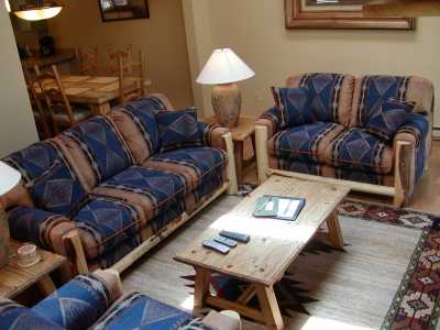Living room features a wood burning fireplace, flat screen TV with DVD player.  French doors open to the deck which overlooks Gore Creek.
