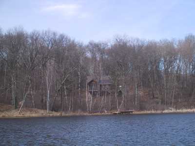 view of house from Rainbow lake in springtime