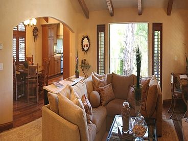 Beautiful Living Room with Hardwood Floors, Vaulted Ceilings, Fireplace and French Doors that open to Rear Terrace overlooking lovely gardens with grill and outdoor dining furniture.