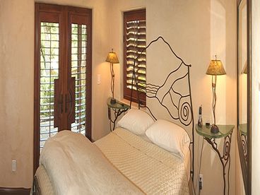 Lovely Second Bedroom with Queen Bed, large flat panel TV and french doors open to rear patio garden.
