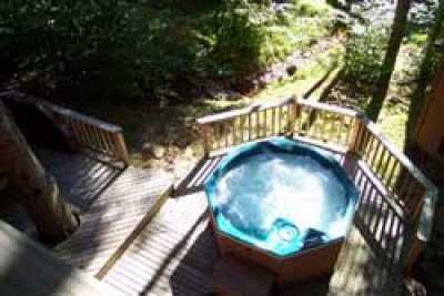 At AN INTERLUDE a hottub on the deck overlooks the mountain stream