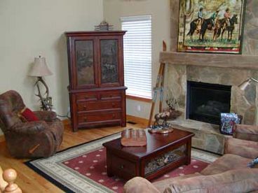 Main living room with gas fireplace and flat screen TV.