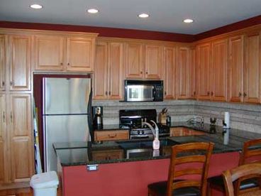 Fully equipped kitchen with granite countertops and breakfast bar.