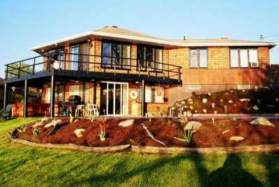 VIEW OF HOUSE FROM THE RIVER - Upper Deck, Lower Patio