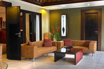 An open air living area equipped with ceiling fan, dinning table and rattan couch. Have your sumpsious breakfast here listening the the sound of water casecade and view of the large swimming pool and private tropical garden.