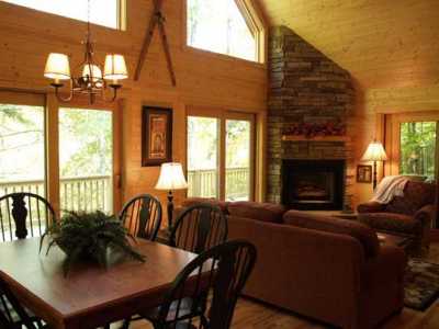 Great room has a gas log fireplace, a TV with DVD, vaulted ceilings and hardwood floors.