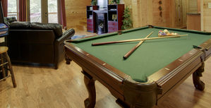 Large game room with pool table, video arcade, fireplace, TV and wet bar.  