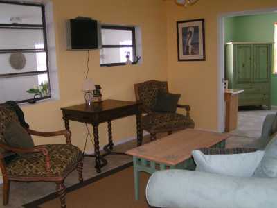 Living Room has a sofa, 2 chairs, Game table and Flat Screen TV